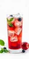 Refreshing berry drink with ice cubes and mint leaves in a tall glass on a light background photo