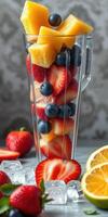 Fresh fruit blend with strawberries, blueberries, and pineapple in a tall glass for a refreshing summer drink photo
