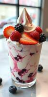 Delicious swirl of creamy yogurt topped with fresh strawberries, raspberries, and blackberries in a clear cup photo