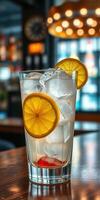Refreshing drink with lemon slices and ice served in a modern bar setting during the evening photo