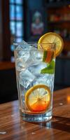 Refreshing drink with ice and lemons served in a clear glass on a wooden table during a sunny afternoon in a cozy cafe photo