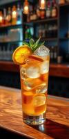 Refreshing iced beverage garnished with lemon and mint in a cozy bar setting at night photo