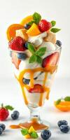Delicious dessert featuring a colorful mix of fruits and ice cream in a glass sundae cup photo
