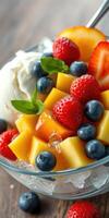 Fresh fruit salad with mango, strawberries, blueberries, and ice cream served in a clear bowl photo