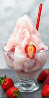 Refreshing strawberry ice dessert served in a glass with vibrant red strawberries and a straw photo