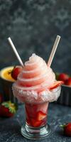 Refreshing strawberry slush topped with whipped ice and served in a glass with two straws photo