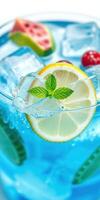 Refreshing beverage with mint, lemon, and berries in vibrant blue liquid photo