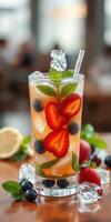 Refreshing berry beverage with mint and lemon served in a clear glass on a wooden table photo