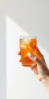 Refreshing iced tea served in a clear glass with lemon slices in bright sunlight photo