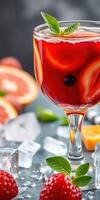 Refreshing drink with citrus slices and berries garnished with mint on a gray background with ice cubes photo