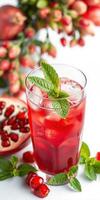 Refreshing pomegranate drink garnished with mint leaves served on a white table with flowers photo