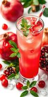 Refreshing pomegranate drink garnished with mint leaves and surrounded by fresh fruit photo