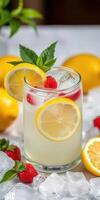 Fresh raspberry lemonade served with lemon slices and mint leaves in a glass, surrounded by vibrant lemons and raspberries photo
