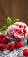 Delicious scoop of raspberry sorbet served with fresh raspberries and mint leaves on crushed ice photo