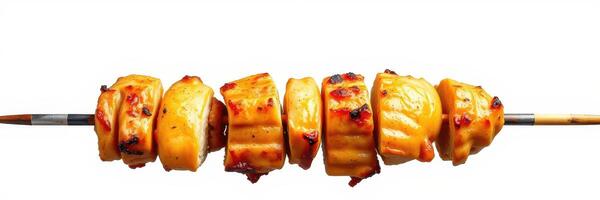 Grilled skewers of marinated chicken arranged on a skewer against a plain background photo