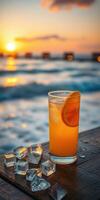 Enjoying a refreshing cocktail by the beach during sunset with waves in the background photo
