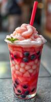 Delicious fruit drink with vibrant colors and creamy topping enjoyed on a sunny day photo