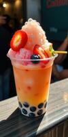 Colorful bubble tea topped with fruit and shaved ice in a vibrant setting during the afternoon photo