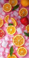 Bright citrus fruits and ice cubes create a refreshing summer display on a vibrant pink background photo