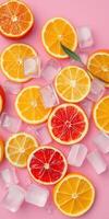 Bright citrus slices and ice cubes arranged on pink background create a refreshing summer vibe perfect for drinks and desserts photo