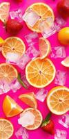 Colorful citrus and ice cubes create a refreshing summer vibe on a bright pink background photo