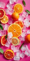 Bright citrus fruits with ice cubes on a vibrant pink background create a refreshing summertime feel photo