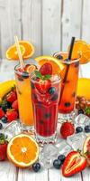 Colorful fruit cocktails with fresh berries and citrus displayed on a wooden table photo