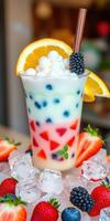 Colorful fruit dessert beverage served in a clear cup garnished with berries and orange slice in a bright setting photo