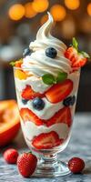 Delicious dessert creation featuring strawberries, blueberries, and creamy whipped topping in a glass photo