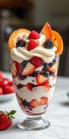 Delicious berry parfait with layers of whipped cream and fresh fruit on a marble table photo