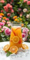 Refreshing citrus drink in a pitcher with fresh oranges and ice against a vibrant floral background photo