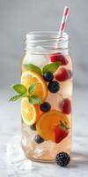 Refreshing fruit-infused drink with citrus and berries in a glass jar on a light background photo
