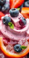 Colorful dessert featuring creamy yogurt topped with fresh blueberries and red fruit garnished with mint leaves photo