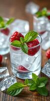 Refreshing raspberry mint drink served over ice in a clear glass on a rustic wooden table photo