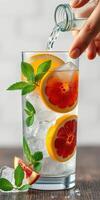 Refreshing citrus cocktail with mint and ice captured in a close-up setting during a sunny afternoon gathering photo