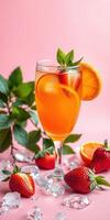Refreshing fruit cocktail served in a glass with strawberries and mint on a pink backdrop photo