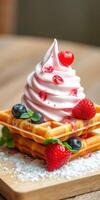 Delicious dessert featuring waffles topped with swirl of cream, fresh strawberries, and blueberries at a cozy cafe setting photo