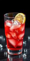 Refreshing red beverage with lemon slice and ice cubes in a glass on a dark background photo