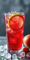 Refreshing red drink with ice and fruit garnishes on a gray background photo