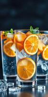 Refreshing citrus drinks filled with ice and garnished with mint leaves served in tall glasses photo