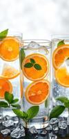 Refreshing citrus drink garnished with mint leaves served in tall glasses with ice cubes photo