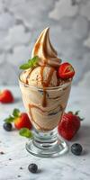 Delicious dessert featuring creamy ice cream topped with sauce and fresh strawberries photo