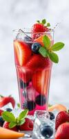 Refreshing summer drink garnished with mint, featuring vibrant fruits like strawberries and blueberries photo