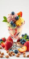 Colorful ice cream sundae topped with fresh fruits and nuts on a white background photo