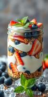 Fresh yogurt parfait with layers of granola, strawberries, and blueberries in a glass jar photo
