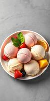 Colorful dessert bowl filled with assorted ice cream flavors and fresh fruits garnished with mint leaves photo