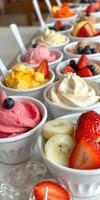 Colorful assortment of frozen desserts with fresh fruit toppings displayed appealingly at a dessert shop photo