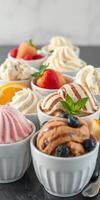 Assorted ice cream cups display with fresh fruit and toppings at a dessert shop photo