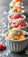 Delicious ice cream scoops served in white ramekins with fresh fruits on a gray marble surface photo