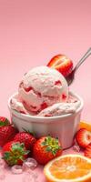 Strawberry ice cream served in a bowl with fresh strawberries and citrus on a pink background photo